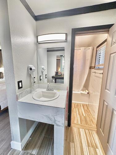a white bathroom with a sink and a mirror at Cascade Lodge Boutique in Bend