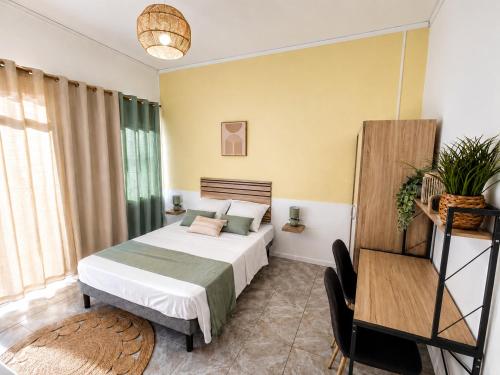 a bedroom with a bed and a chair in a room at Harmony Caraibes in Le Robert