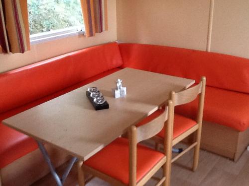アラタにあるMobile Home proche Golfe de Lavaのテーブル(椅子2脚付)と赤いソファ