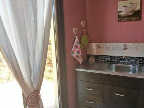 a kitchen with a sink and a window at The Olive Tree House in Kompítsion