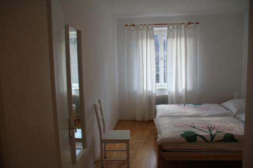 a bedroom with a bed and a chair and a window at Ferienhaus Vera in Obervellach