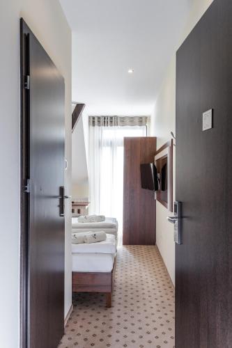 two beds in a room with a door open at Fregata in Ełk
