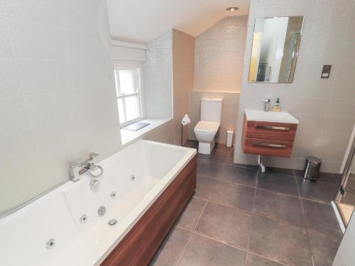 a bathroom with a tub and a toilet and a sink at Kelsick Heights in Ambleside