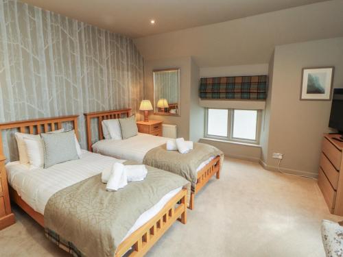 a bedroom with two beds and a television in it at Kelsick Heights in Ambleside