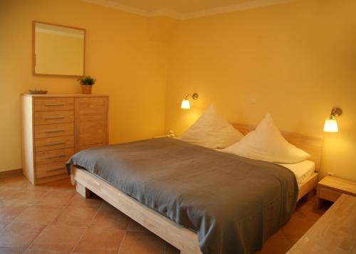 Schlafzimmer mit einem Bett, einer Kommode und einem Spiegel in der Unterkunft Ferienwohnung Strandläufer in Börgerende-Rethwisch