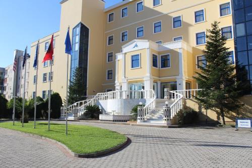 a building with flags in front of it at Adriatik Hotel, BW Premier Collection in Durrës