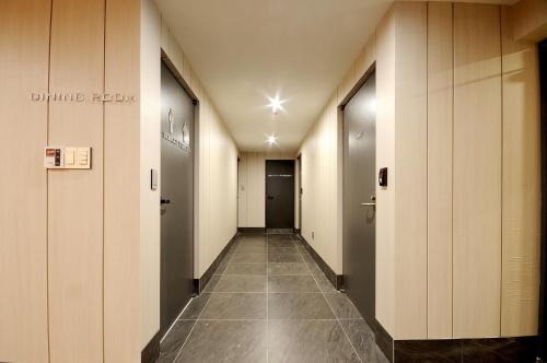 a corridor of an office building with doors and tile floors at Queens Hotel Seomyeon Busan in Busan