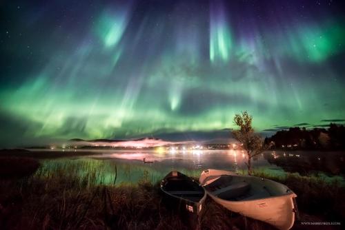 two boats sitting on a field under the aurora at Ylläksen Yöpuu in Äkäslompolo
