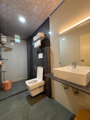 a bathroom with a white toilet and a sink at Andaman Beach Resort in Shādipur
