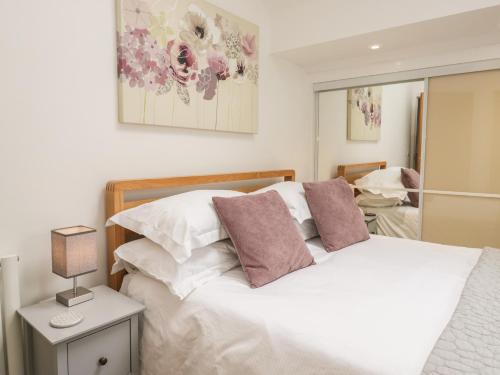 a bedroom with a bed with white and purple pillows at Coney Garth Barn in Beckermet