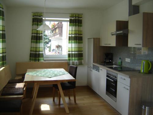 une cuisine avec une table en bois, une table, une table et une fenêtre dans l'établissement Biohof Stockinger, à Kirchbach