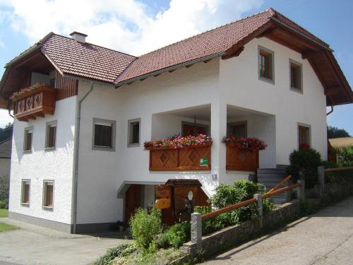una gran casa blanca con flores en el balcón en Biohof Stockinger, en Kirchbach