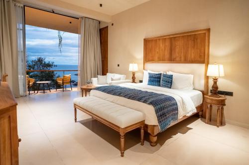 a bedroom with a large bed and a balcony at Tombolo Bay in Dickwella