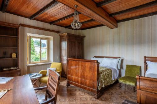 a bedroom with a bed and a table and chairs at Lake Orta Villa Retreat in Pella