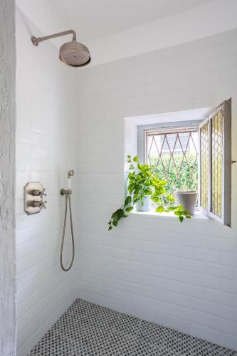 a white bathroom with a shower and a window at Lake Orta Villa Retreat in Pella