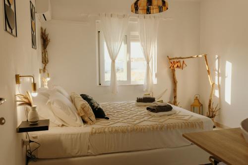 a bedroom with a large white bed with a window at Villa Helia in Kos