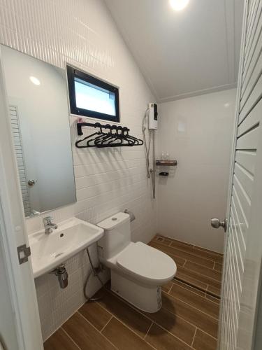 a bathroom with a toilet and a sink and a window at Honeymoon in Pong Talong