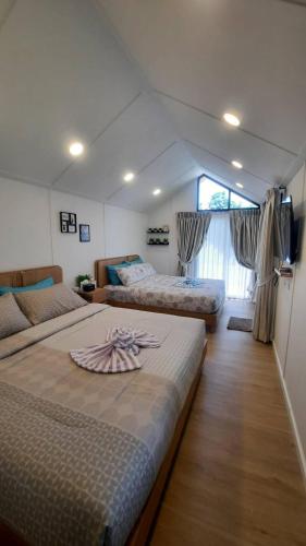 a bedroom with two beds and a large window at Honeymoon in Pong Talong