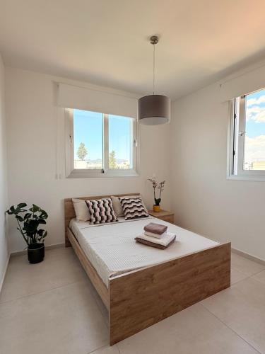 a bedroom with a large bed and two windows at Esmee In, Engomi in İncirli