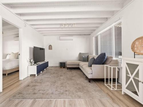 a living room with a couch and a tv at Pepper Cottage - Easy Beachside Living Close to Town in Dunsborough