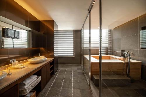a bathroom with a shower and a tub and a sink at Holiday Inn Gwangju by IHG in Gwangju
