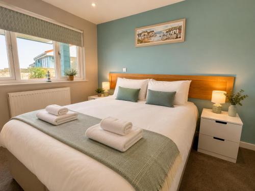 a bedroom with a large bed with towels on it at Seaside Escape in Westward Ho! 3-Bed Family Holiday Home with Sea Views in Westward Ho
