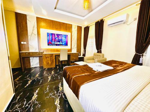 a hotel room with a bed and a flat screen tv at Presken Hotel Castle, Opebi Lagos in Lagos