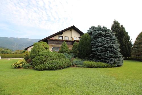 uma casa com um monte de árvores num quintal em Frühstückspension Eichberger em Pöls