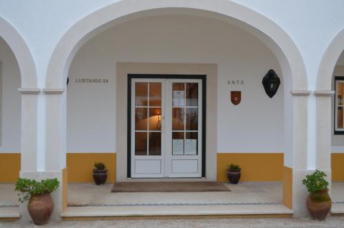un ingresso a un edificio con porta bianca di Lusitanus a Golegã