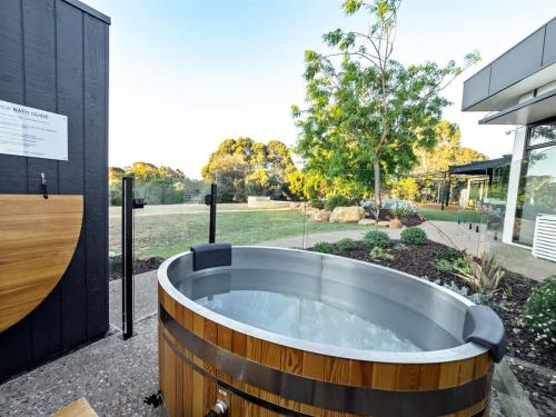 a large wooden tub sitting outside of a building at Seaview Yallingup - Nature & Spa Sanctuary in Yallingup