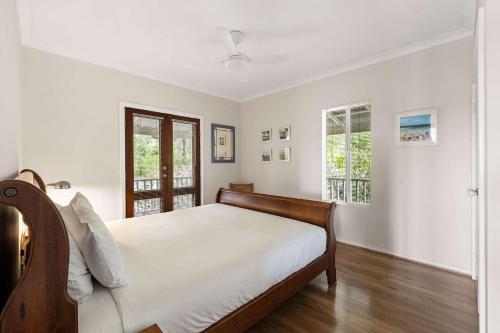 a bedroom with a bed and two windows at Hillview - Spacious Bushland Haven with Resort Access in Yallingup