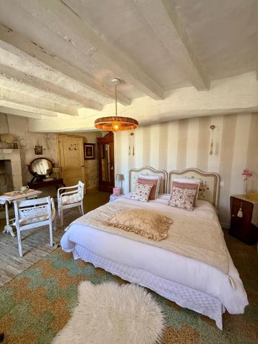 a bedroom with a large bed with a chandelier at La vallée des grottes in Saint-Germain-sur-Vienne