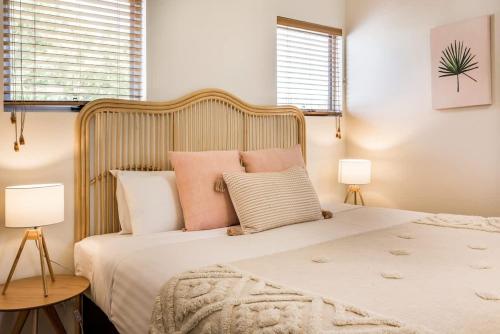 a bedroom with a large bed with pink pillows at Banksia at Whitesands - Villa 5 Loft-Style Living by the Bay in Dunsborough