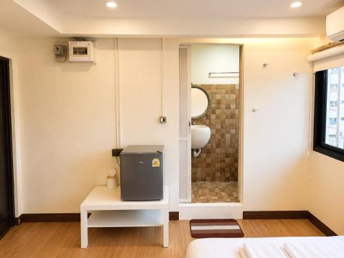 a bathroom with a toilet and a sink in a room at Sukhum Ratchada Sutthisan in Bangkok