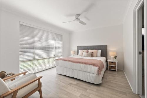 a white bedroom with a bed and a window at Luna Getaway in Quindalup