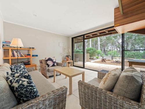 a living room with a couch and a table at Rosella - Secluded Bushland Escape with Valley Views in Yallingup