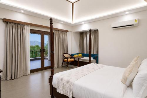 a bedroom with a bed and a view of a balcony at Aamba Bagh Resort Kumbhalgarh in Kumbhalgarh