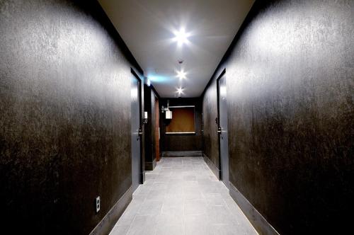 a hallway with dark wood walls and a hallway with a corridorngthngthngthngth at Queens Hotel Seomyeon Busan in Busan