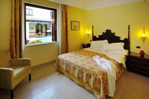 a bedroom with a bed and a window and a chair at Arciduca Grand Hotel in Lipari