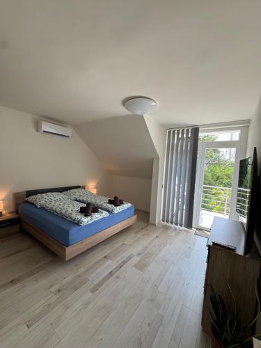 a bedroom with a bed and a large window at Villa Palma Balatonboglár in Balatonboglár