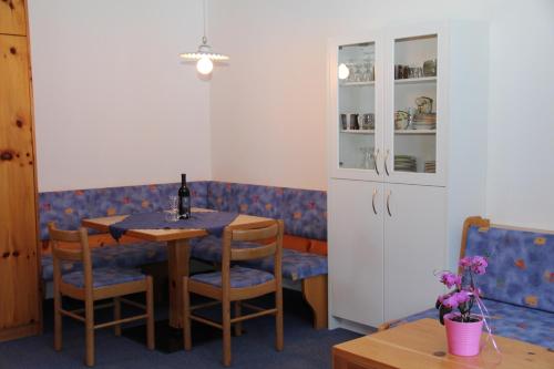 a dining room with a table with a bottle of wine at Alpina Residence in Solda