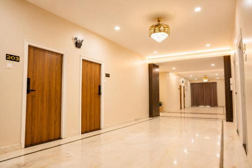 an empty hallway with doors and a chandelier at Hotel SSV Suites Premium Near HItech City, Madhapur in Hyderabad