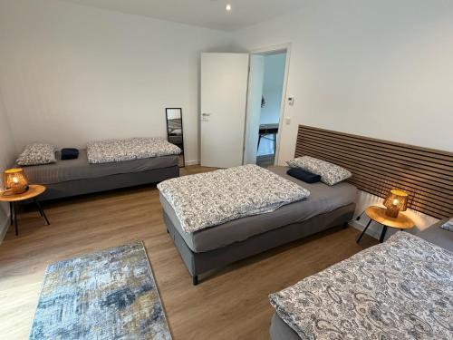 a room with three beds and two tables at Idar Apartments 11 in Idar-Oberstein