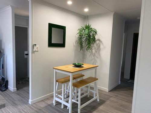 a small table with two stools in a room at Ocean Breezes with Leafy View with Wi-fi in Slade Point