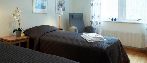 um quarto de hotel com duas camas e uma cadeira em Mullsjö Folkhögskola em Mullsjö
