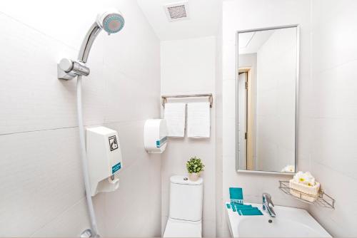 a bathroom with a toilet and a sink and a mirror at Hotel 81 Elegance in Singapore