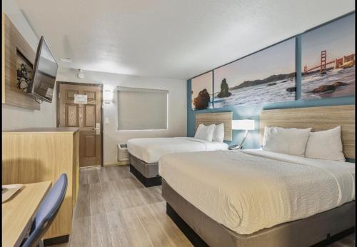 a hotel room with two beds and a tv at Days Inn Merced / Yosemite Area in Merced