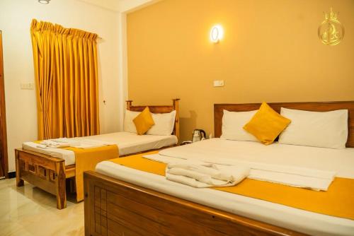 a hotel room with two beds with towels on them at Anoo Garden Villa in Trincomalee