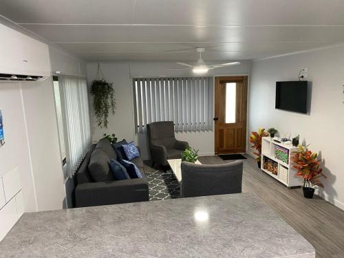a living room with two chairs and a tv at Seaside Breezes with Wi-fi in Slade Point
