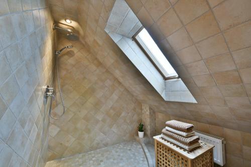 a attic bathroom with a shower and a skylight at Atostogų namelis Druskininkuose in Druskininkai